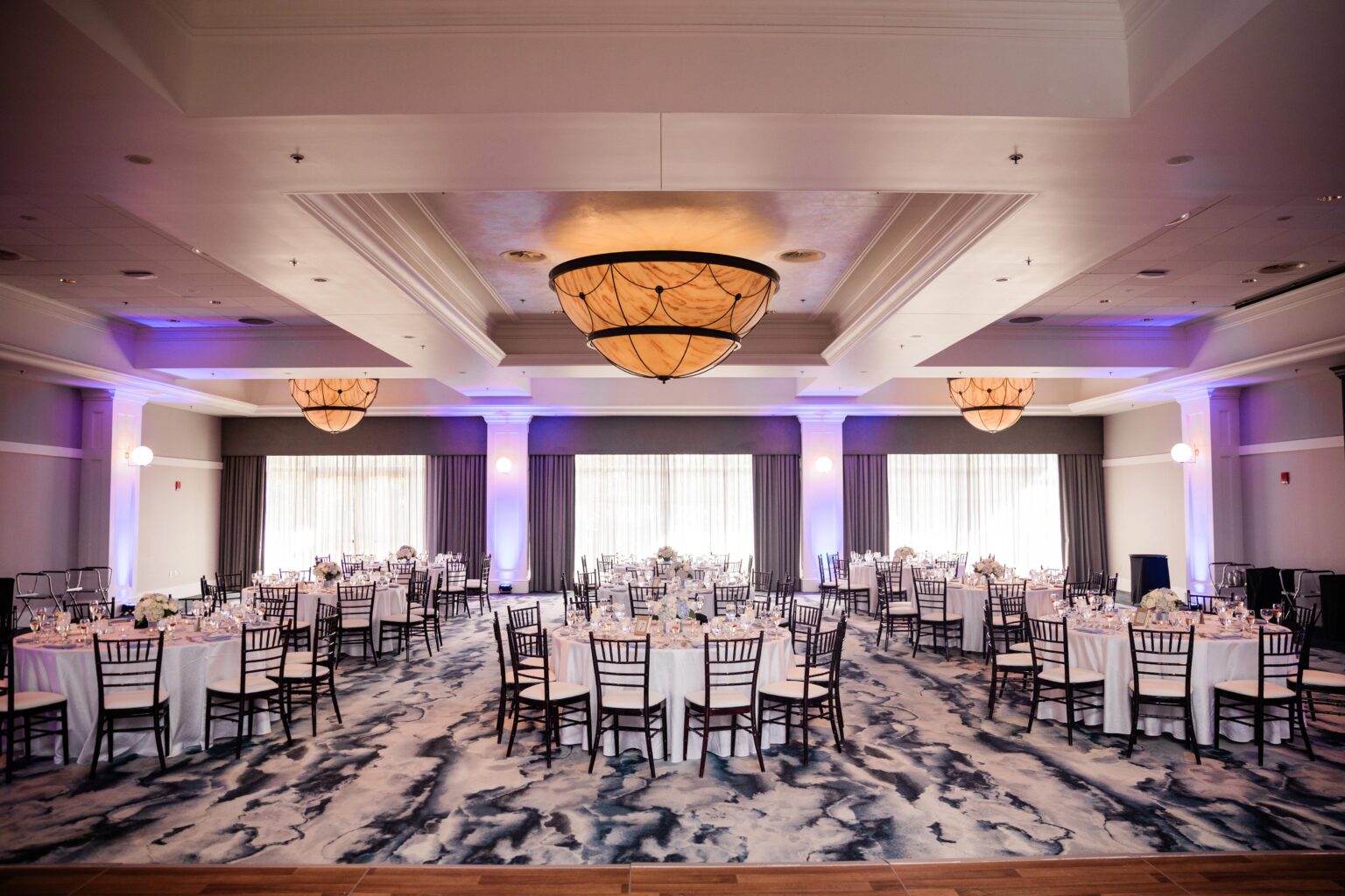 Elegant hotel ballroom wedding reception with purple accent lighting