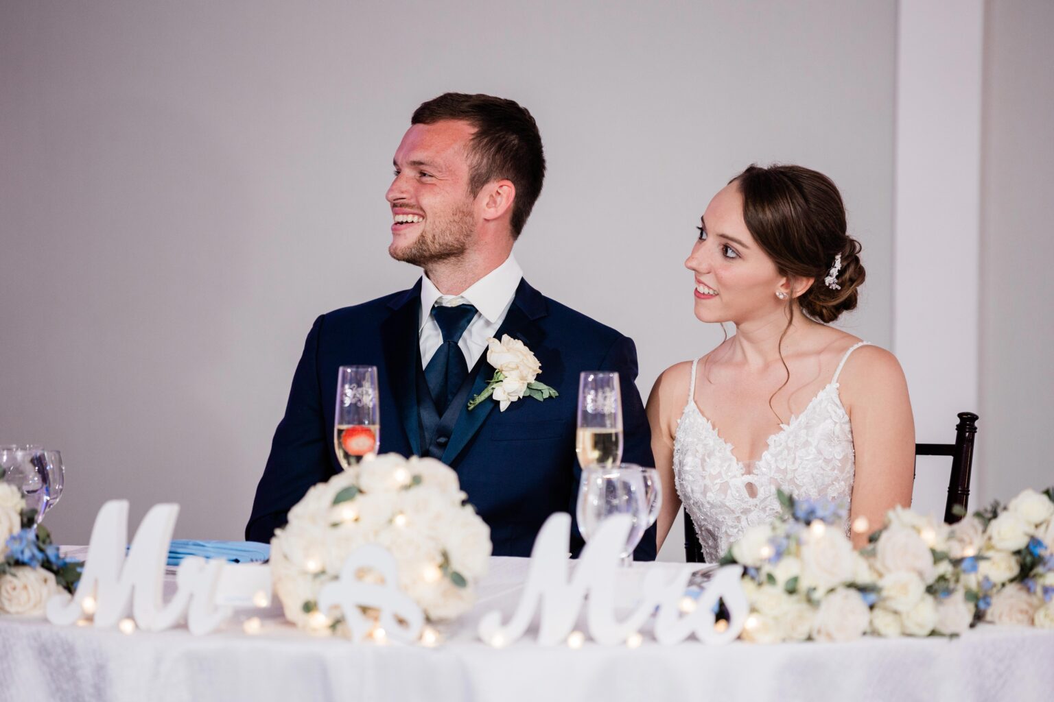 bride and groom listen to toasts at their hotel ballroom wedding reception